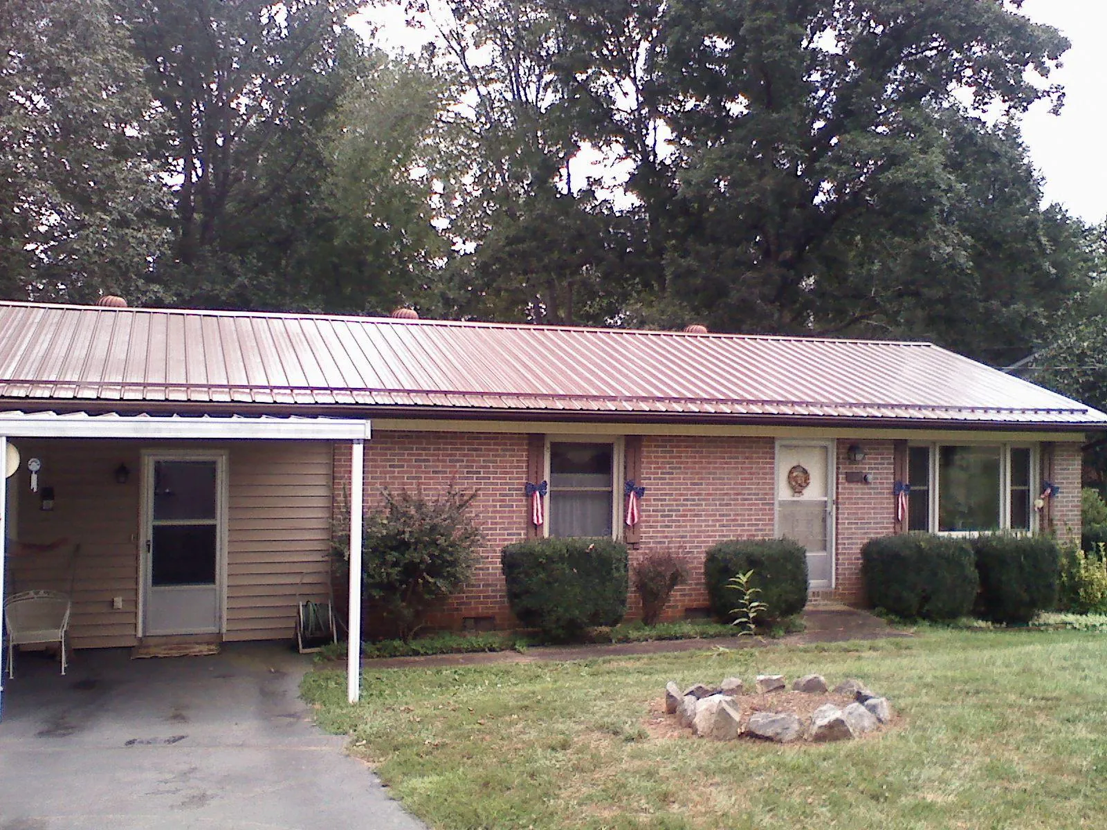 Bronze metal roof and carport on a brick ranch home — Roof Repair work by our crew in Norwalk